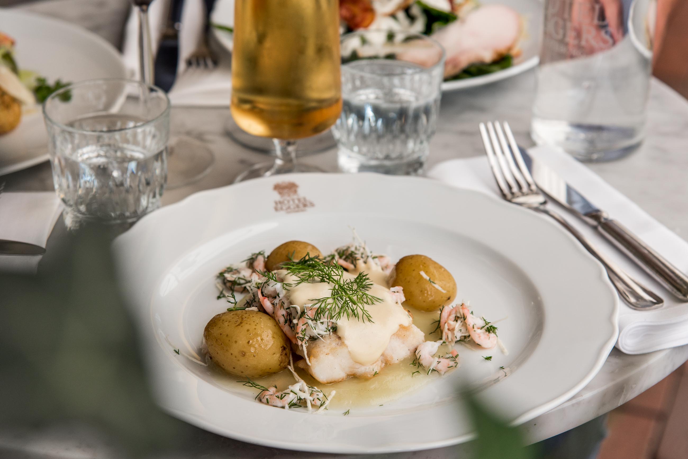 Lunch på Hôtel Eggers, Torsk och kokt potatis som serveras med Brynt smör och räkor