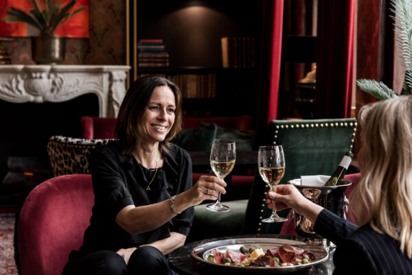 Två kvinnor skålar med vin i lobbyn