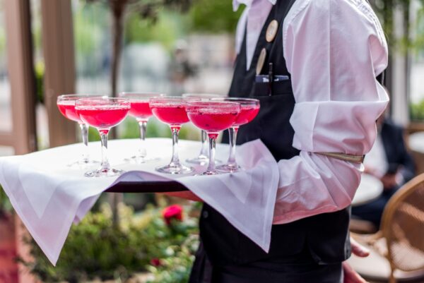 servitör med drinkar på bricka