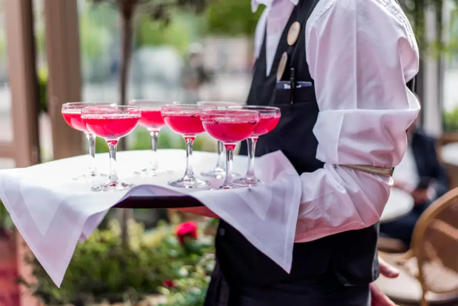 servitör med drinkar på bricka