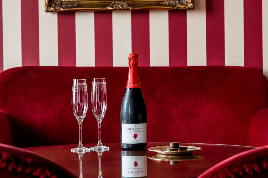 vip på rum med en flaska cava och praliner