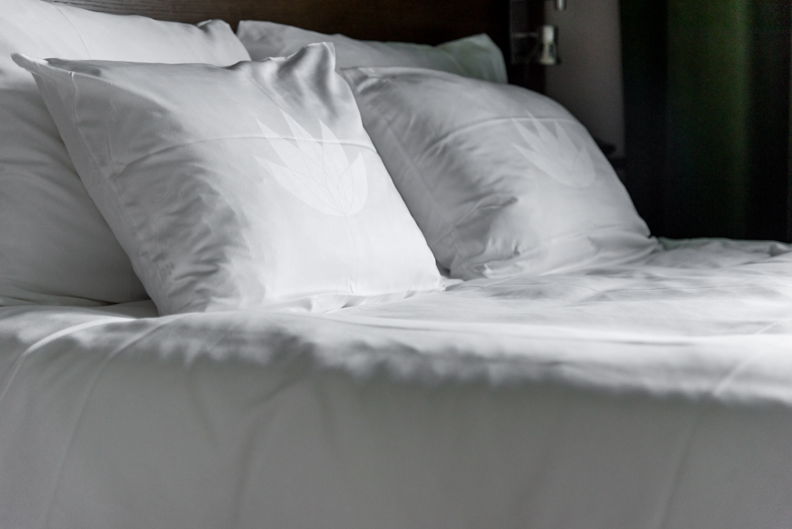 bed made up with white sheets and pillows